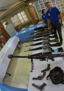 Director Carlos T. Sol Jr. of the combined secretariat of the GPH-CCCH and the AHJAG inspects the firearms recovered during the operation.
